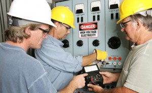 commercial electricians working on a panel